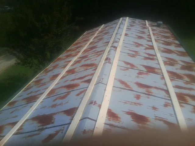 Rusted metal roof panels with new wood purlins before replacement — Storm Damage Roof Repair in Grantsville by Roofing Brothers